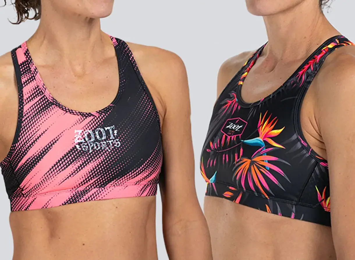 Two women wearing ROI Swift sports bras with vibrant, colorful designs, showcasing activewear for fitness and sports activities.